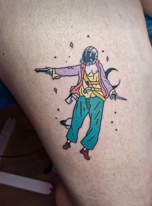 Foto van een menselijk figuurtje in magische context. De tattoo werd op de dij gezet.