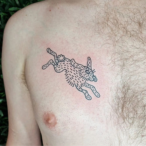 Foto van een tatoeage van een konijn of haas. De klant heeft de tatoeage laten zetten op zijn borst.