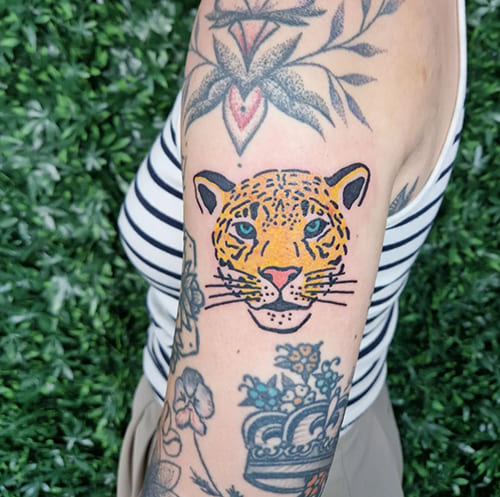 Foto van een illustratieve tattoo van een jaguar of luipaard op de bovenarm.