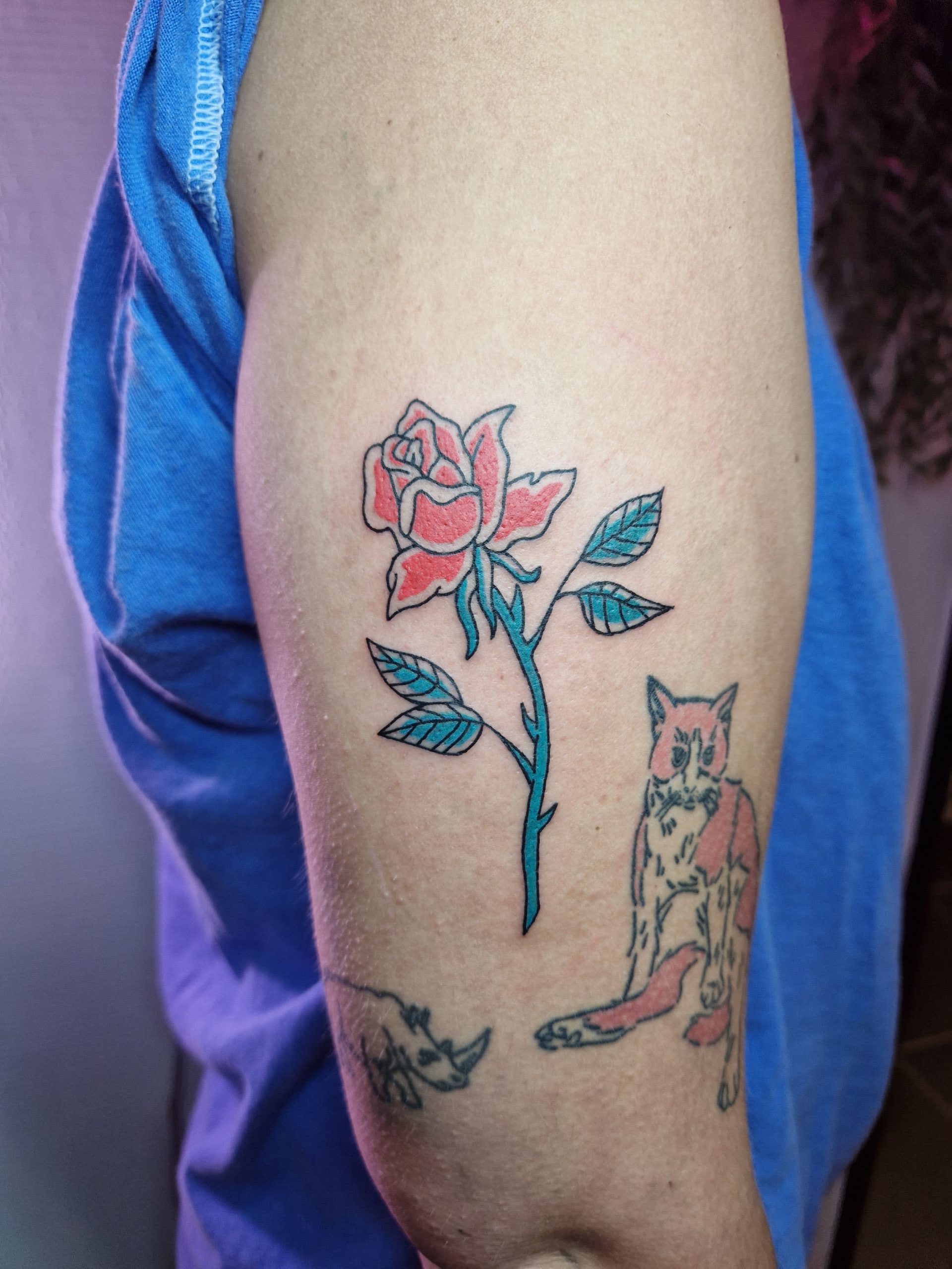 Foto van een tattoo door Caudali Tattoo. Het is een ingekleurde tattoo van een roos.