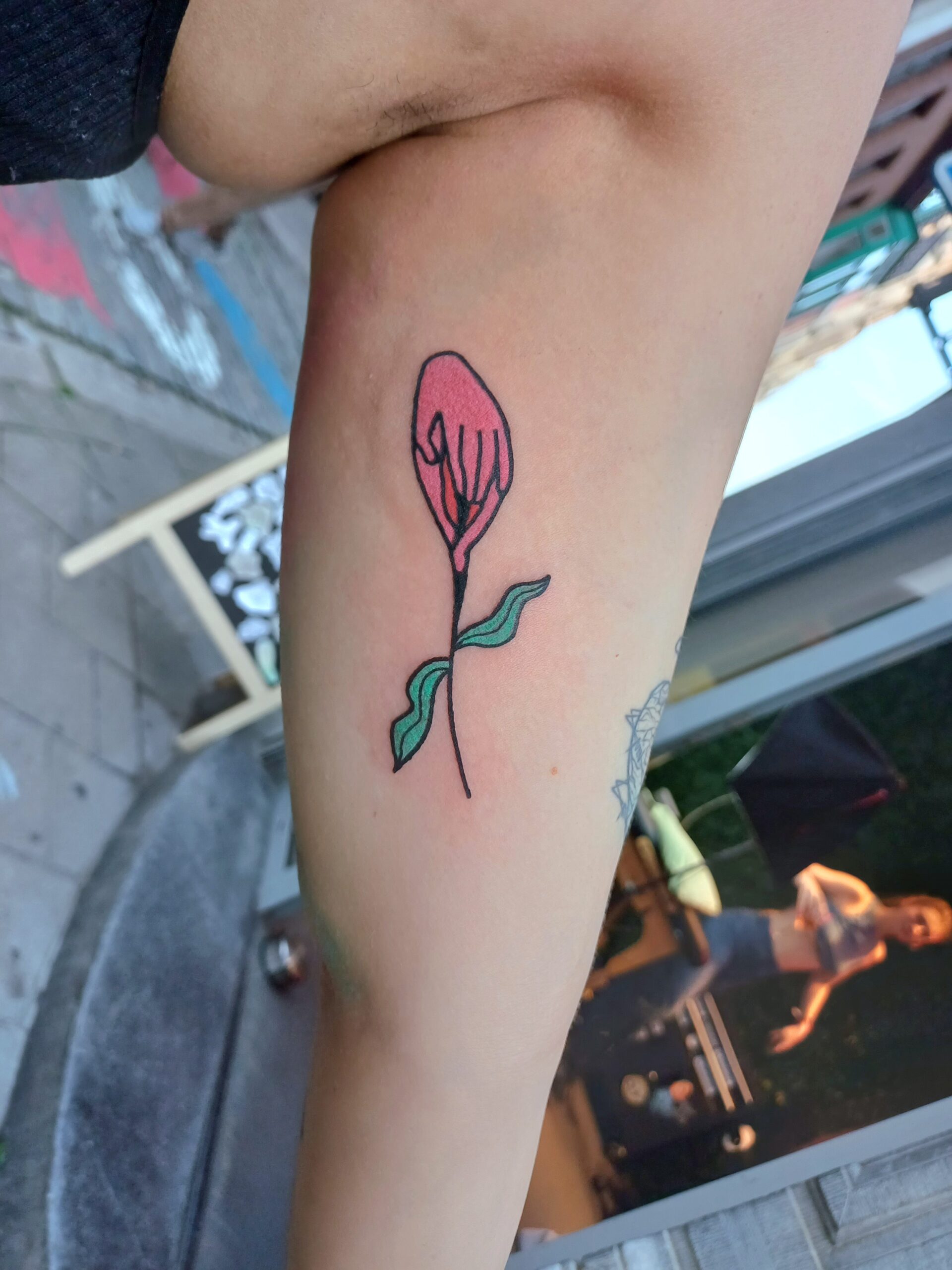 Foto van een tatoeage van een bloem. De tattoo werd op het bovenarm gezet.