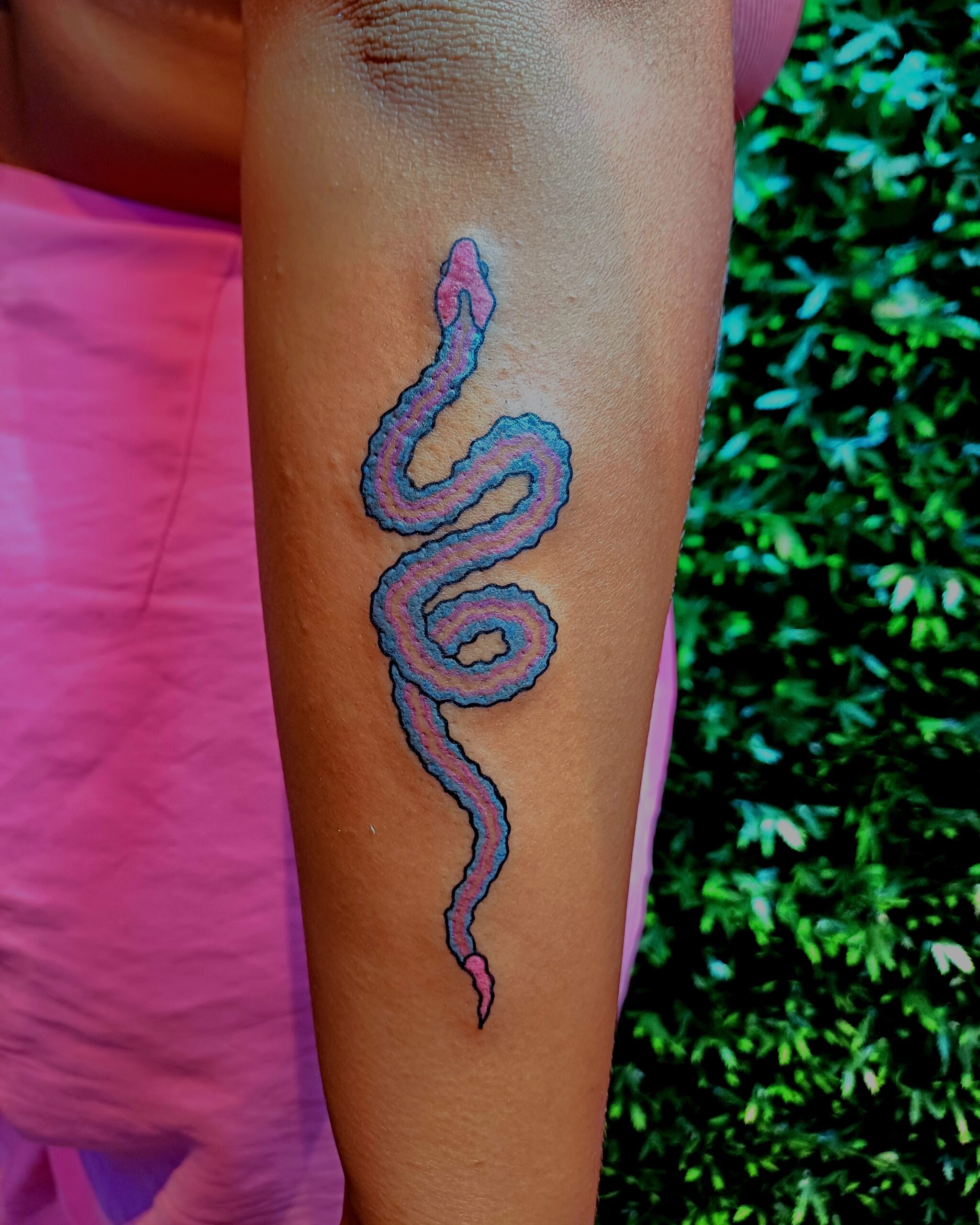 Foto van een tatoeage op de onderarm. Het is een kleurenversie tattoo van een slang.